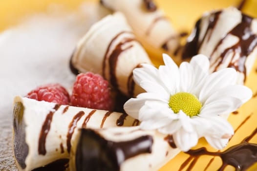 Piece of cake on plate with berries and fruits and camomile