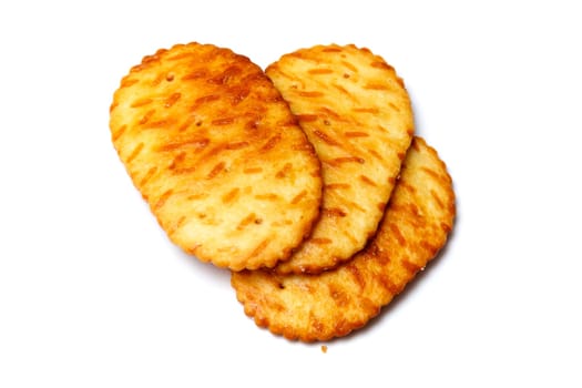 Three baked crackers, cookies or biscuits over white.