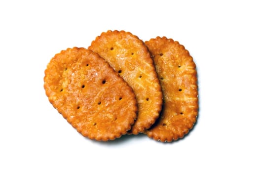 Three baked crackers, cookies or biscuits over white.