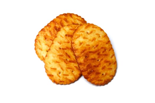 Three baked crackers, cookies or biscuits over white.