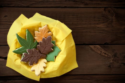 Different Autumnal Cookie Leaves in a Yellow Bowl on Wood