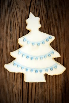 A Christmas Tree Cookie with Blue and White Icing as Decoration