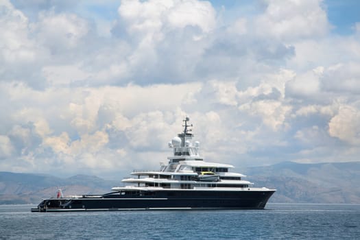 Gigantic big and large luxury mega yacht with helicopter landing place on the blue ocean. Investment for millionaires.