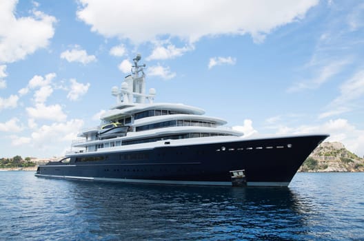 Gigantic big and large luxury mega yacht with helicopter landing place on the blue ocean. Investment for millionaires.