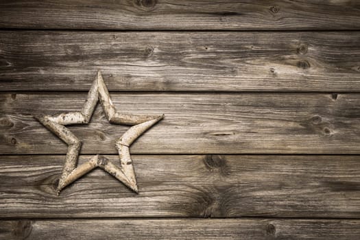 Wooden christmas background with a handmade star for decoration.