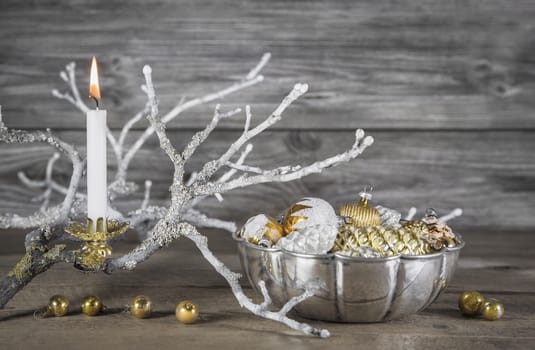 Vintage or shabby chic christmas background with one burning candles in gold and silver colors.