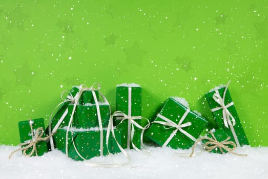 Green christmas presents on white snowy background.
