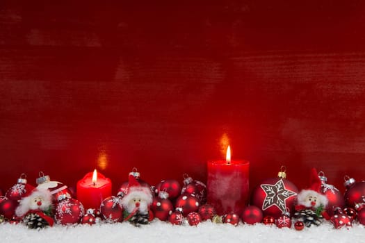 Red wooden christmas background with two burning candles - classic decoration.