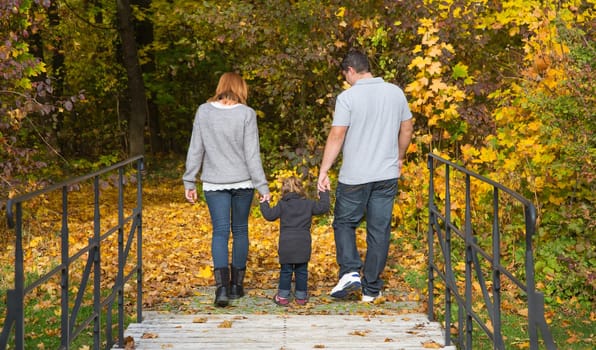 Happy young family in autumn making a walking tour in the nature.