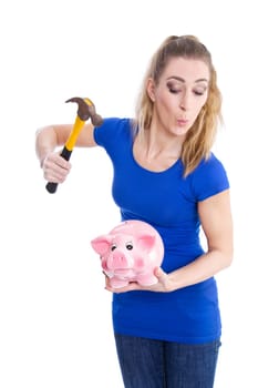 Crazy young and isolated blond woman breaking her pink piggy bank wearing blue shirt.