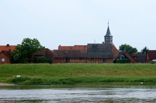 The photograph of the city of Wahrenberg on the river Elbe behind a dike.