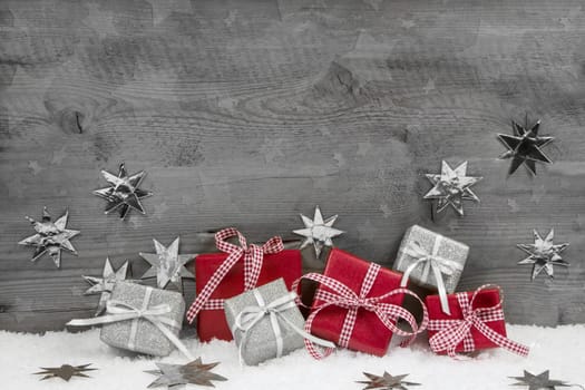 Christmas presents in red and silver on wooden grey wooden background.