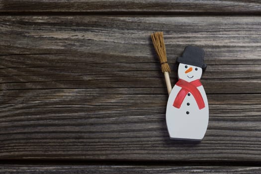 Snowman in red and white color on wooden background for christmas decoration.