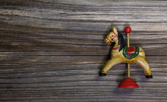 Old antique wooden rocking horse on wooden background for a christmas card.