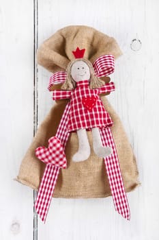 Present bag with angel on white background for christmas in red and white checked
