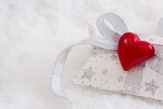 Close up of white an silver present box with red heart for christmas