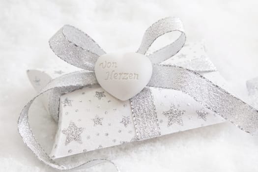 Top view of white and silver present box with white heart for christmas