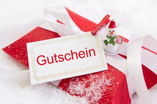 Close up of red christmas present box with German text for a coupon