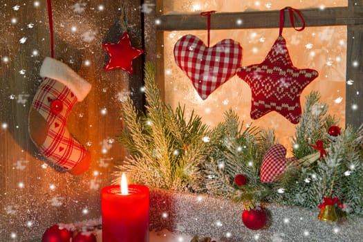 Christmas decoration with red candle on window sill in country style