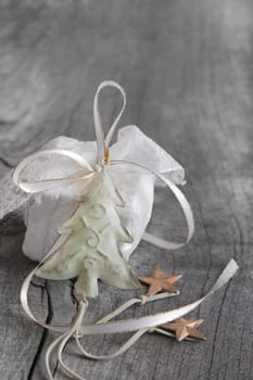 White gift for christmas on a grey shabby chic background with a white golden ribbon for a coupon or a greeting card