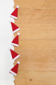 Red christmas hats on wooden background for a greeting card