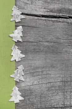 Wooden Christmas trees with green fabric on grey wooden background for a greeting card