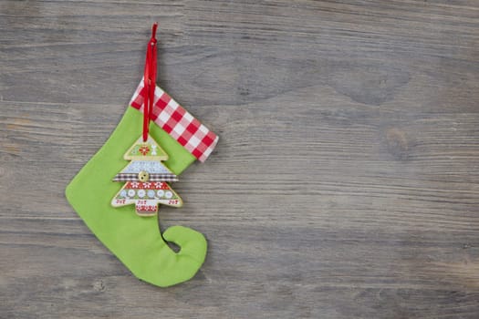 Green santa boots on a shabby wooden background for a christmas card