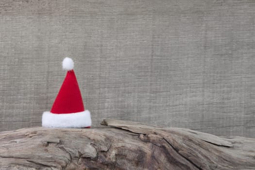 Red Santa hat on trunk - rustical country style background with white, red and wood