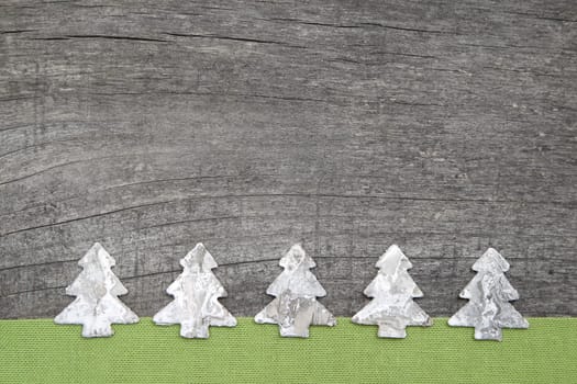 Wooden Christmas trees with green fabric on grey wooden background
