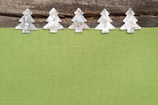 Wooden Christmas trees with green fabric on grey wooden background for a greeting card