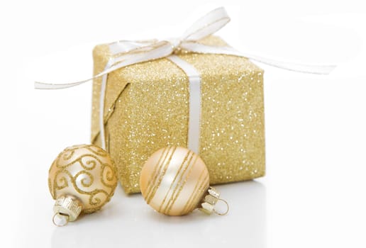 Golden christmas present with bauble decorations isolated on white background for a shopping concept