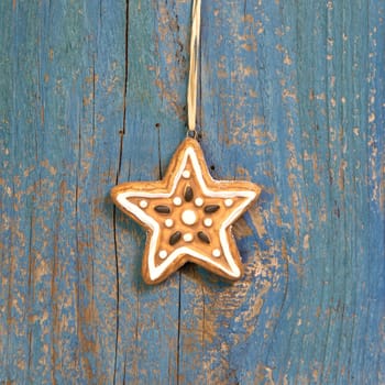 Hanging gingerbread or cookies star on wooden background for christmas