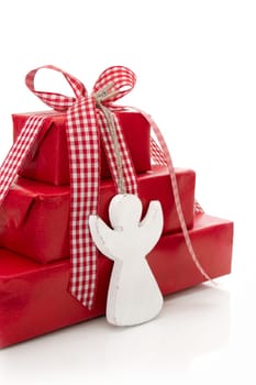 Red christmas presents with a white wooden angel an red checkered ribbon isolated in Country style