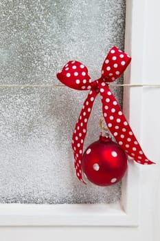 White christmas background with snow - shabby chic style with a red ball and a red dotted ribbon with snow