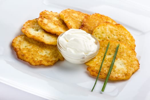 Potato Pancake with sour cream on white background