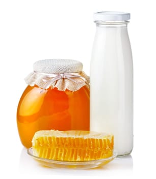 Sweet honey pouring from wooden dipper in glass bowl isolated on white