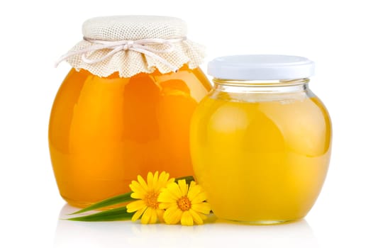 Sweet honey pouring from wooden dipper in glass bowl isolated on white