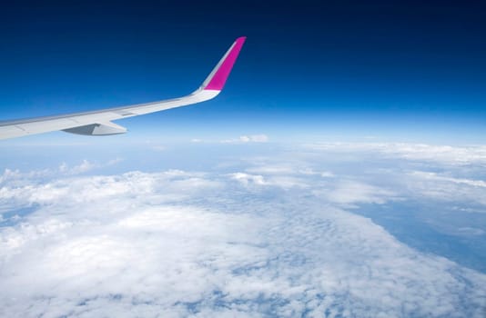Plane wing and clouds viewed from airplane