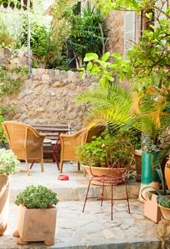 Traditional courtyard with chairs and a lot o flowers in old village in Mallorca island, Spain