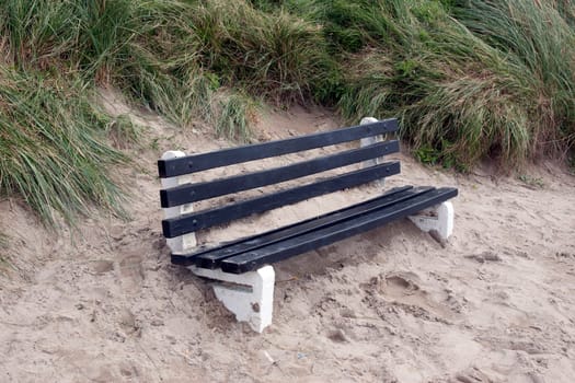 bench covered in sand from the winter storms in Ireland