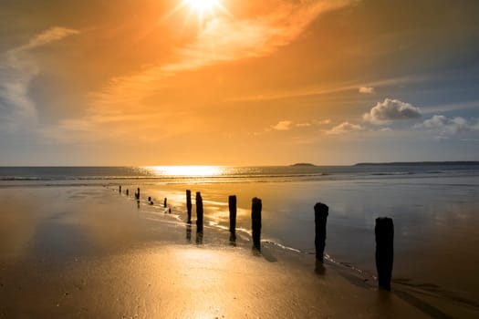 golden sunshine over the beach breakers in Youghal county Cork Ireland on a summers day