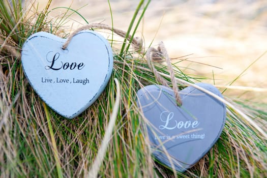 two blue wooden love heart in dunes on an Irish beach