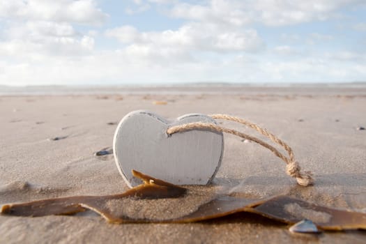 single wooden love heart in the sand on a wild Atlantic way Irish beach in summer