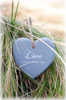 single blue wooden love heart in dunes on an Irish beach