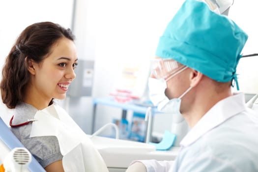Young girl looking at her doctor in clinic