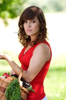Young woman with basket filled fresh vegetables