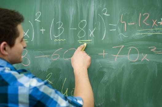Student boy writing mathematical formula