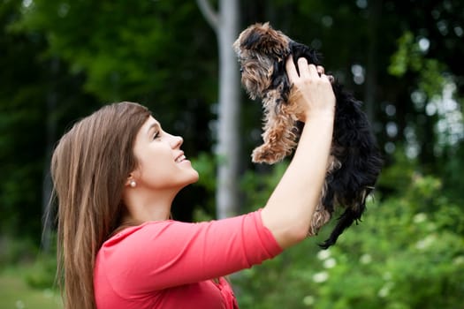 Smiling woman holding cute puppy