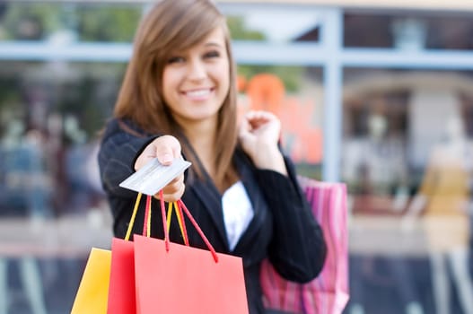 Young woman with shopping bags and credit card
