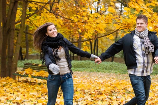 Beautiful young couple running in the park